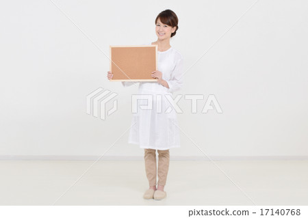 A woman holding a cork board with a smile A woman holding a cork board with a smile 17140768