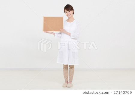A woman holding a cork board with a smile A woman holding a cork board with a smile 17140769
