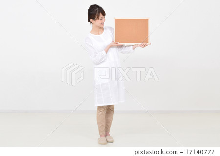 A woman holding a cork board with a smile A woman holding a cork board with a smile 17140772