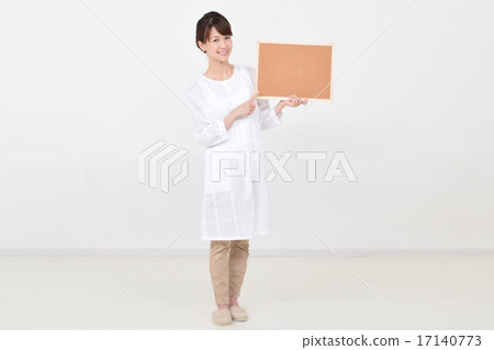 A woman holding a cork board with a smile A woman holding a cork board with a smile 17140773