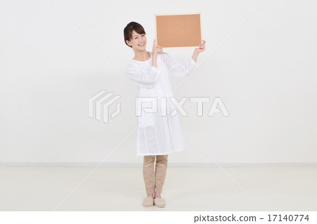 A woman holding a cork board with a smile A woman holding a cork board with a smile 17140774