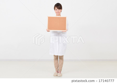 A woman holding a cork board with a smile A woman holding a cork board with a smile 17140777