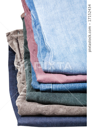 stack of various jeans and corduroys close up 17152434