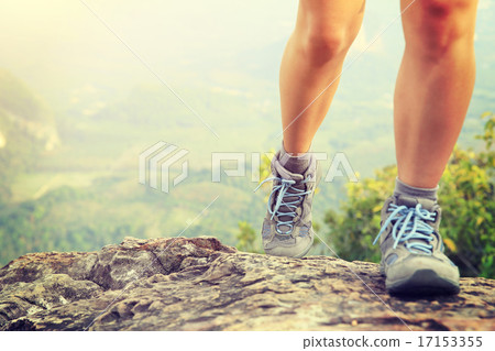 Stock Photo: woman hiker legs climbing rock at mountain peak