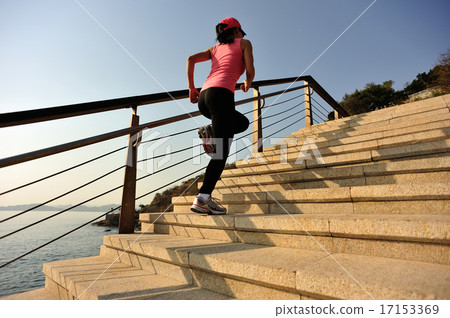 sports woman running up on stone stairs easide 17153369