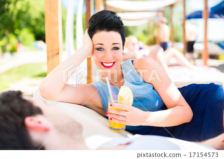 Couple in beach bar relaxing with drinks 17154573