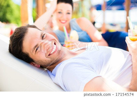 Couple in beach bar relaxing with drinks Couple in beach bar relaxing with drinks 17154574