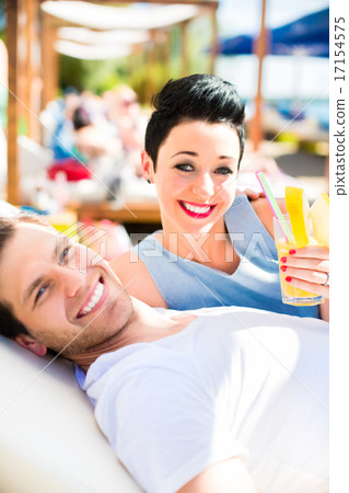 Couple in beach bar relaxing with drinks 17154575