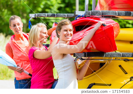 Three women unloading kayak from boat trailer 17154583