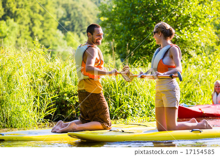 Woman and man with stand up paddle board Woman and man with stand up paddle board 17154585