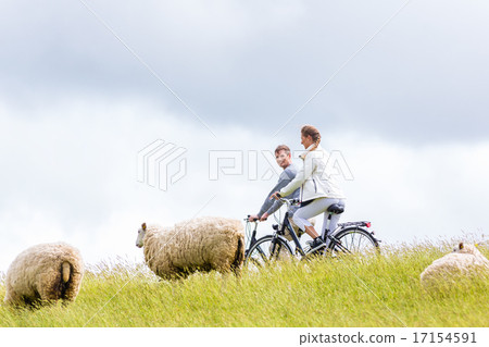 Couple having sea coast bicycle tour at levee Couple having sea coast bicycle tour at levee 17154591