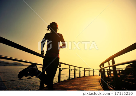 sports woman running on wooden boardwalk sunrise   17155230