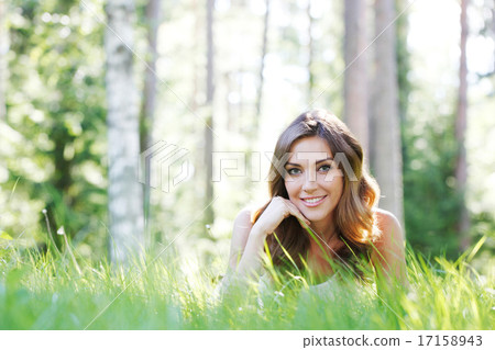 young woman in white dress lying on grass young woman in white dress lying on grass 17158943