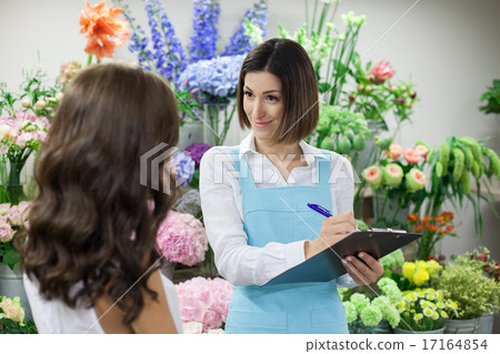 Attractive saleswoman is serving customer in flower shop 17164854