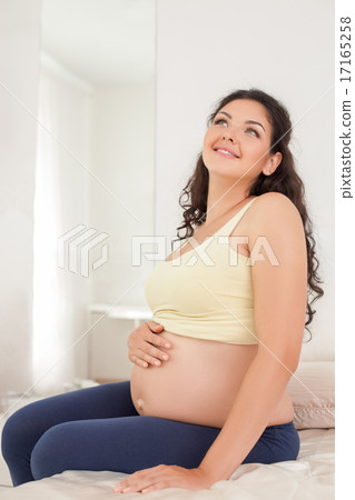 Pretty young expectant mother is dreaming about future 17165258