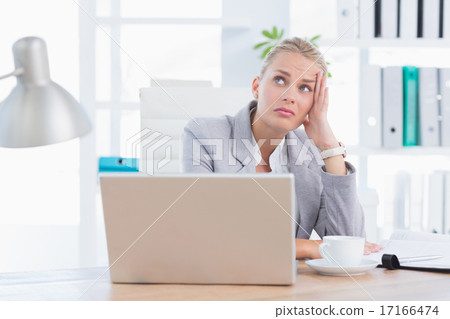 Frustrated businesswoman with head in hand Frustrated businesswoman with head in hand 17166474