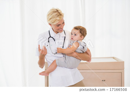 Smiling blonde doctor and child with stethoscope 17166508
