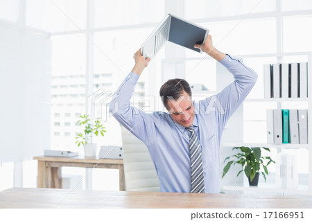 Irritated businessman trying to broke his laptop 17166951