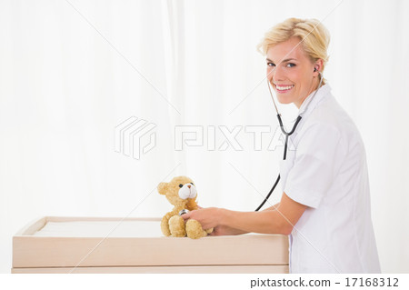 Portrait of a blonde doctor with stethoscope and teddy bear 17168312