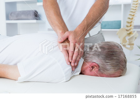 Physiotherapist doing neck massage to his patient 17168855
