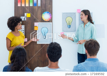 Casual young businesswoman giving presentation to colleagues 17169592