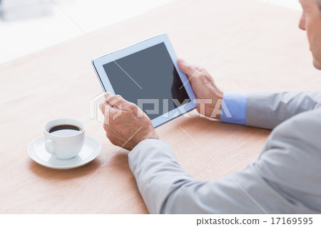 concentrating businessman using a tablet concentrating businessman using a tablet 17169595