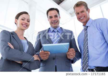 Business colleagues smiling at camera and holding tablet 17171165