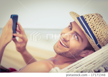 Handsome man texting on the hammock 17171348