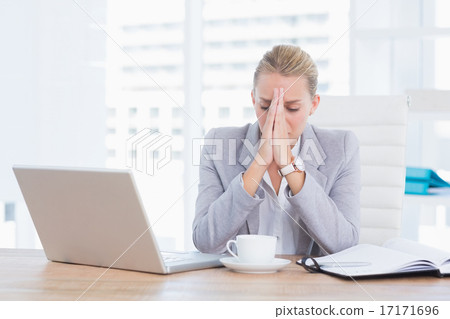 Frustrated businesswoman with head in hands Frustrated businesswoman with head in hands 17171696