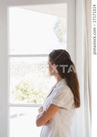 Beautiful brunette woman looking out in the window 17171814