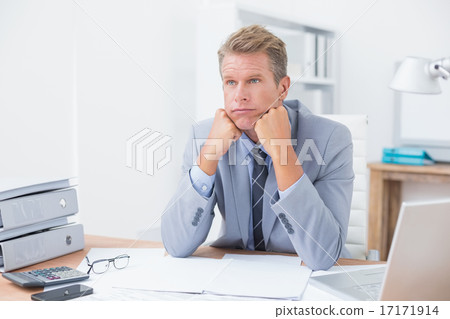 Worried businessman sitting at work Worried businessman sitting at work 17171914