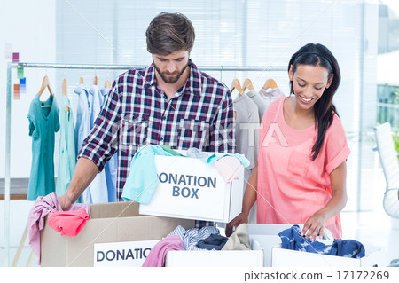Smiling young friends volunteers separating clothes 17172269