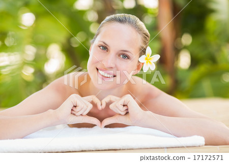 Peaceful blonde lying on towel looking at camera Peaceful blonde lying on towel looking at camera 17172571