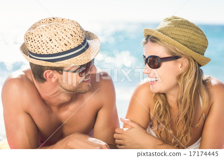 Happy couple relaxing together in the sand 17174445