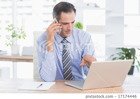 businessman phoning at his desk 17174446