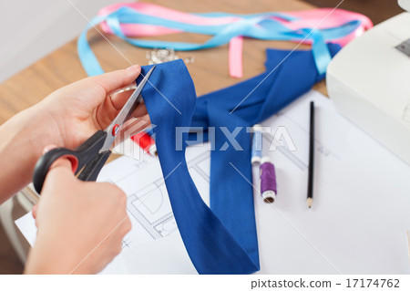 Skilled young sewer is preparing new clothing Skilled young sewer is preparing new clothing 17174762