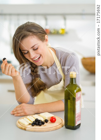 Happy young woman eating fresh cheese and olives 17175692