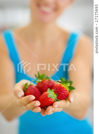 Closeup on smiling young woman giving strawberries 17175693