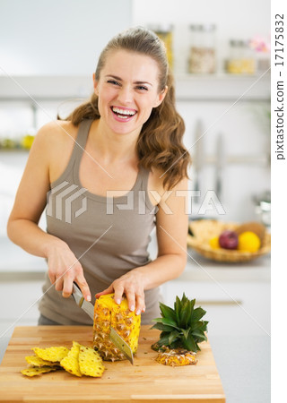 Smiling young woman cutting pineapple Smiling young woman cutting pineapple 17175832