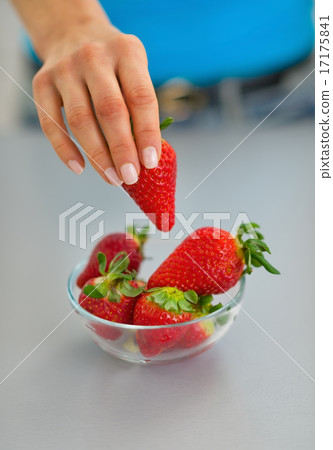 Closeup on young woman taking strawberry 17175841