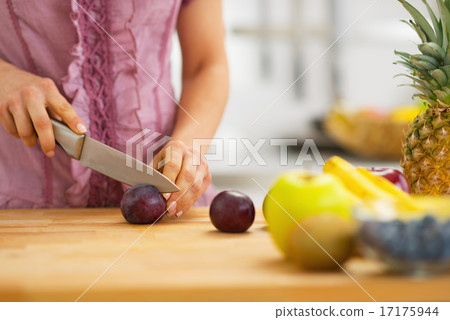 Closeup on young housewife cutting plums Closeup on young housewife cutting plums 17175944