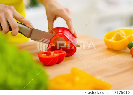 Closeup on housewife cutting red bell pepper on cutting board Closeup on housewife cutting red bell pepper on cutting board 17176010