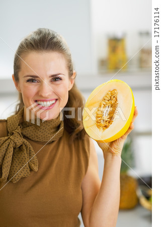 Happy young housewife holding melon slice 17176114