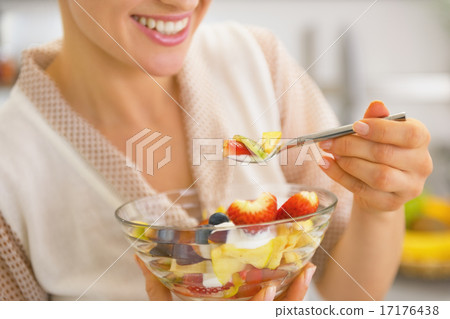 Closeup on young housewife eating fresh fruit salad Closeup on young housewife eating fresh fruit salad 17176438