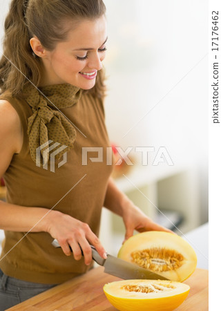 Young housewife cutting melon in kitchen 17176462