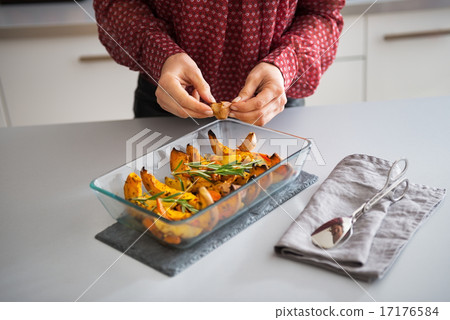 Closeup on young housewife adding garlic to baked pumpkin 17176584