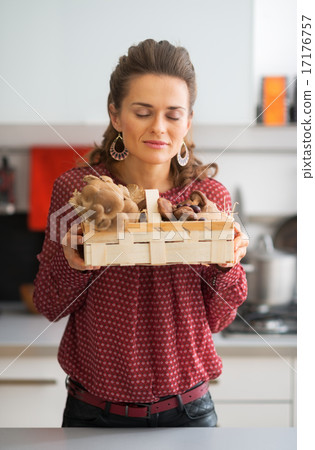 Young housewife enjoying freshness of mushrooms in basket 17176757