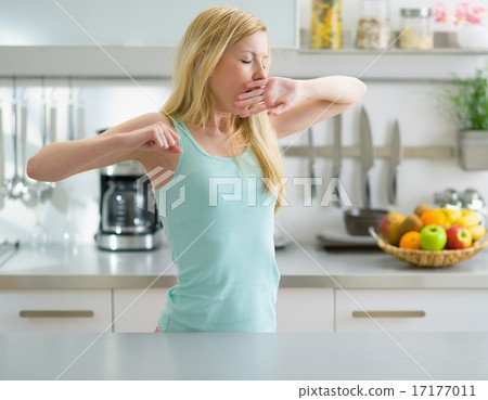 Young woman stretching after sleep in kitchen Young woman stretching after sleep in kitchen 17177011