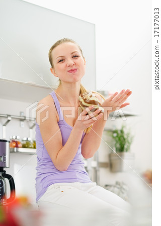 Happy teenage girl eating chocolate cream from jar Happy teenage girl eating chocolate cream from jar 17177013