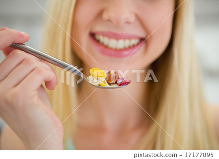 Closeup on spoon with flakes in hand of smiling teenager girl Closeup on spoon with flakes in hand of smiling teenager girl 17177095